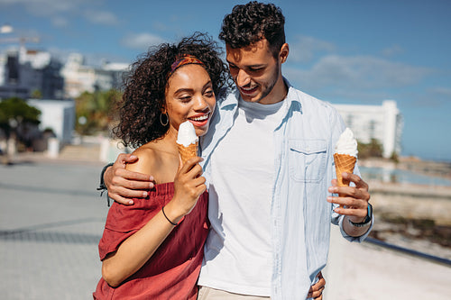 Romantic couple walking on street eating ice cream