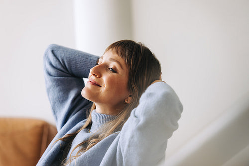 Pensive businesswoman relaxing with her hands behind her head