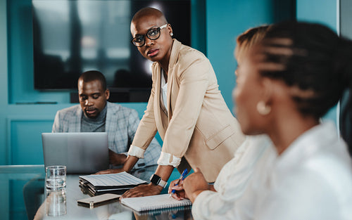 Professional team in a meeting with a focused leader discussing project strategies in a modern office setting
