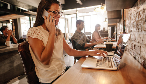 Woman talking with client on mobile phone