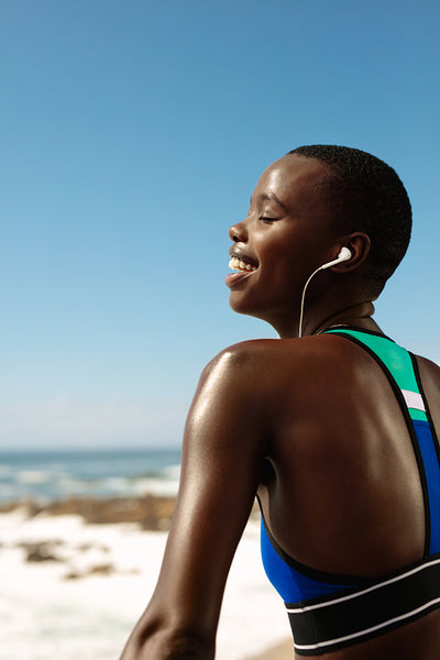 Fitness woman relaxing and listening to music outdoors
