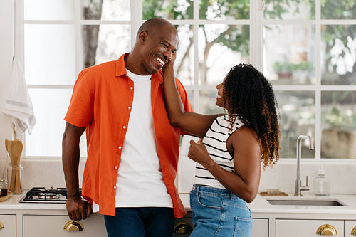 Happy couple laughing in a bright kitchen setting