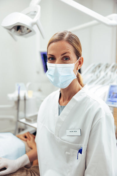 Dentist with face mask in her office