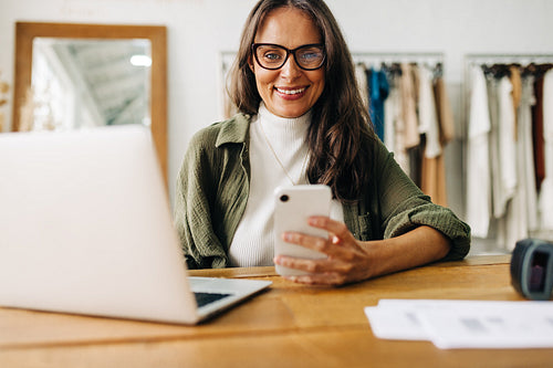 Woman using a mobile phone to coordinate her small business