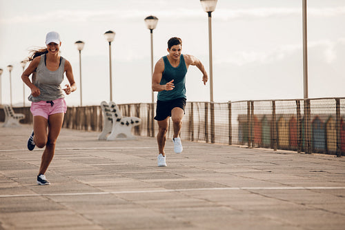 Young people sprinting along a seaside promenade