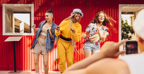 Energetic friends dancing in front of a camera phone