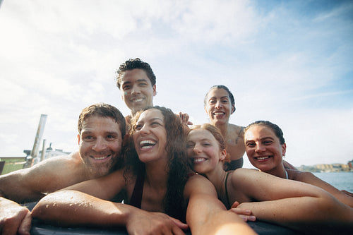 Summer mood shines as friends take a selfie in an outdoor hot tub