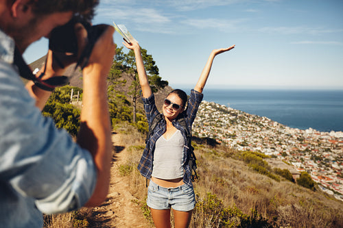 Happy young couple taking pictures while hiking