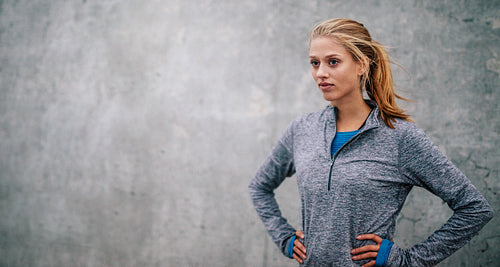 Confident young fitness woman standing outdoors