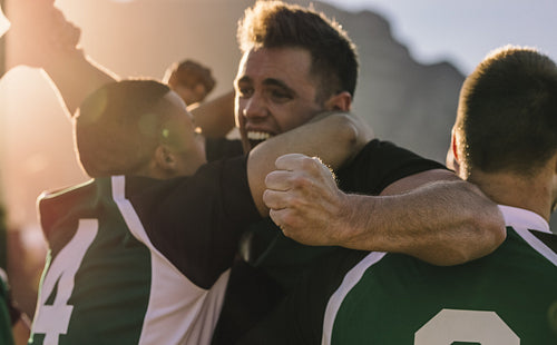 Team of rugby players cheering after victory