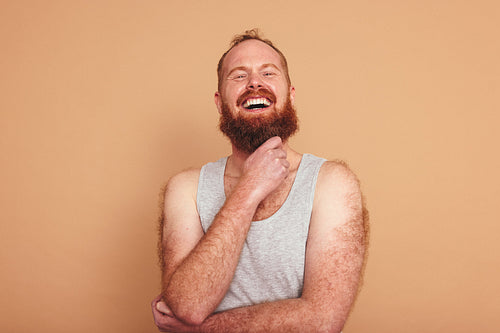 Cheerful man smiling at the camera in a studio