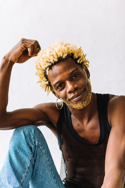 Black queer man posing in a studio
