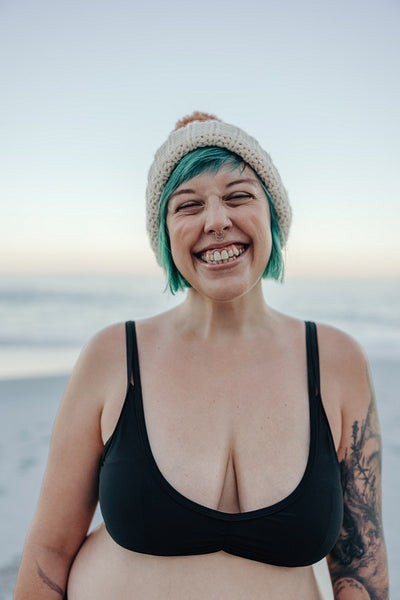 Ecstatic winter bather smiling with her eyes closed at the beach