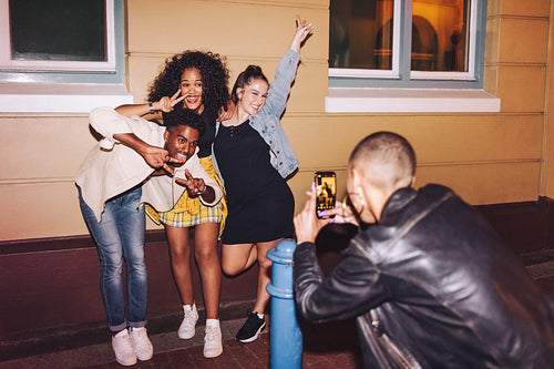 Gen z friends posing for a photo at night