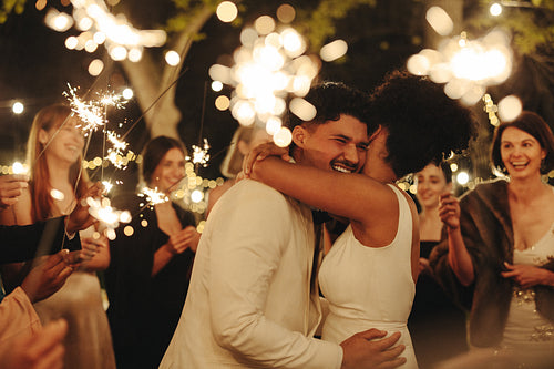 Bride and groom celebrating with sparklers at outdoor wedding reception
