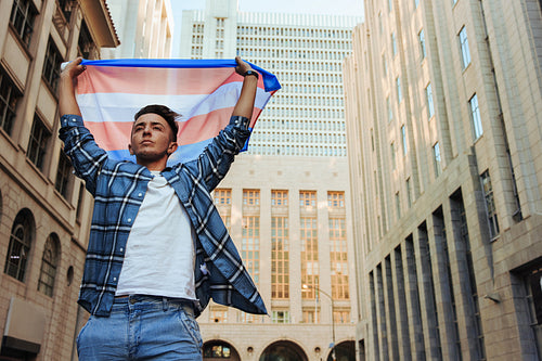 Nonconforming man raising the transgender flag outdoors
