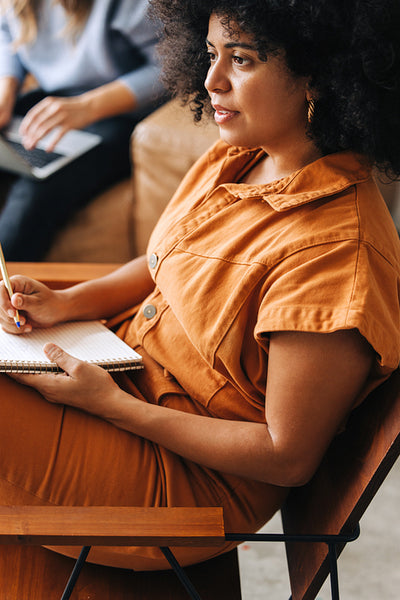 Businesswoman writing in a notebook in an office
