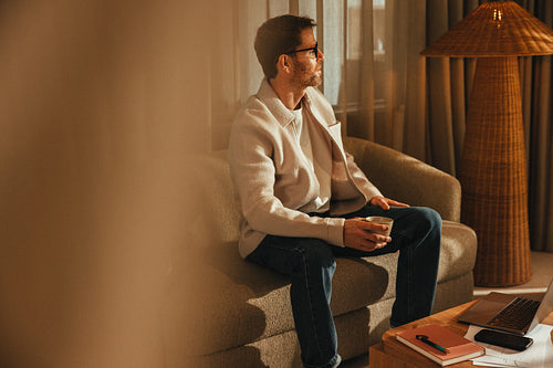Businessman sits with coffee beside a laptop in his office workspace