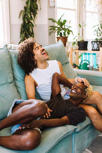 Young gay couple laughing together at home