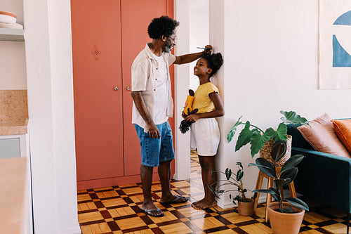 A father's love: Sharing a joyful moment of measuring height with his little daughter
