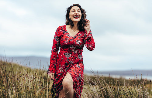 Woman in beautiful red dress exploring the countryside