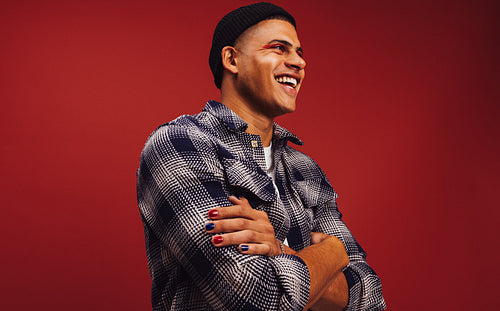 Cross-armed young man smiling in a studio