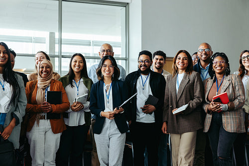 Diverse team of business professionals at a conference with smiling employees and businesswomen