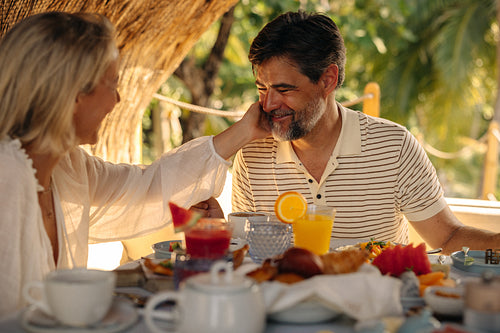 Happy couple enjoying a luxurious vacation breakfast at a tropical destination