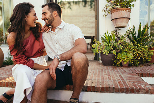 Carefree young couple laughing together outside a hotel