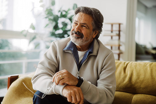Senior man relaxes on a sofa at home in retirement