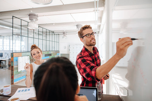 Casual young businessman giving presentation to colleagues