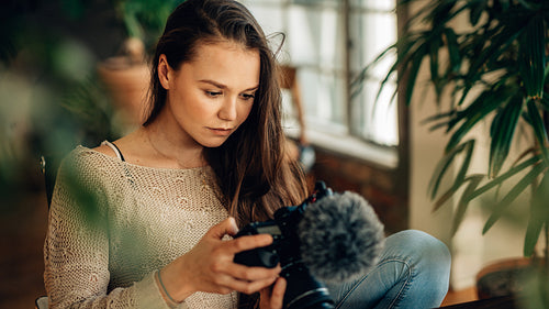 Woman blogger looking at her camera