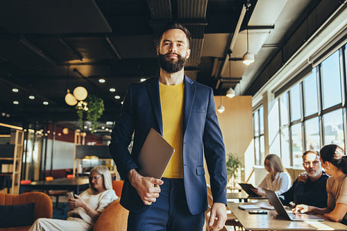 Young businessman standing in a co-working space