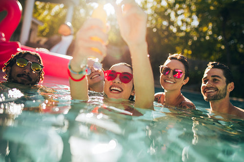 Multiracial group of friends having fun in a pool