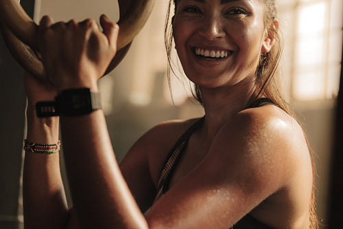 Smiling woman exercising with gymnastic rings
