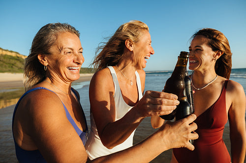 Group of women celebrating friendship with a toast at the beach