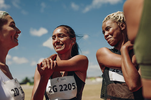 Women runners doing warmup exercises at the stadium