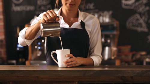 Female barista making a cup of coffee 