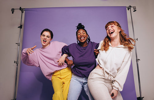 Three multicultural friends dancing and having fun in a studio