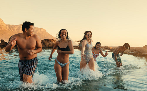 Group of young friends enjoying a holiday beach trip at sunset