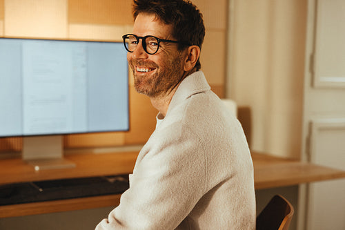 Man works at desk in an office for a creative portrait