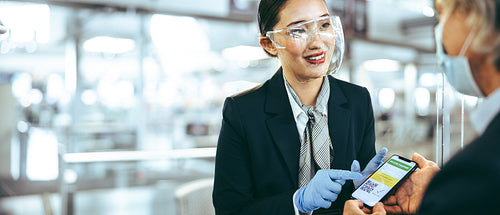 Ground attendant checking vaccine passport of traveler