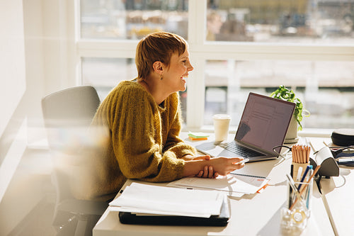 Smiling businessman sitting at her desk