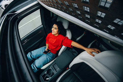 Woman passenger in car using smartphone during relaxed city travel