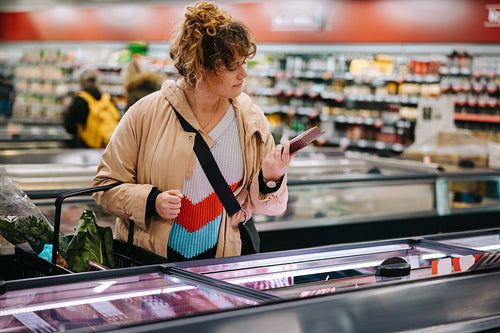 Customer reading product information at supermarket
