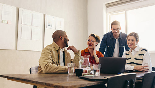 Happy businesspeople watching a presentation on a laptop