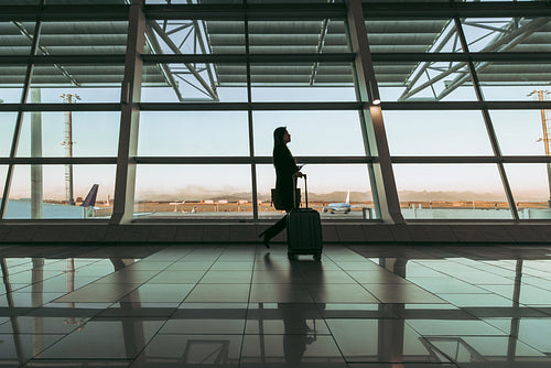 Silhouette of female passenger at airport terminal
