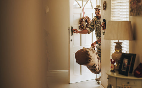 Cheerful young soldier returning home from the military