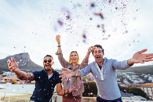 Group of friends enjoying party with confetti