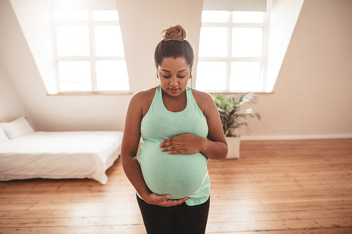 Beautiful pregnant woman practising yoga at home